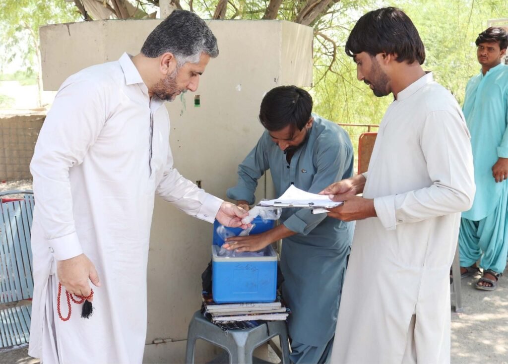 Deputy Commissioner Sevi Major (r) Ilyas Kabzai Polio vaccine ke vials check kar rahe hain